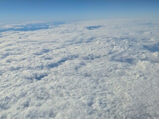 Airplane flying over white clouds background