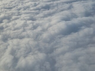 Airplane flying over white clouds background