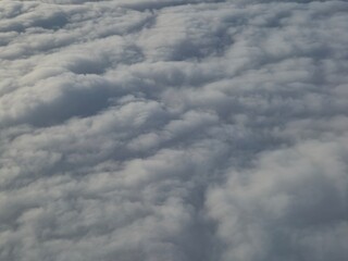Airplane flying over white clouds background