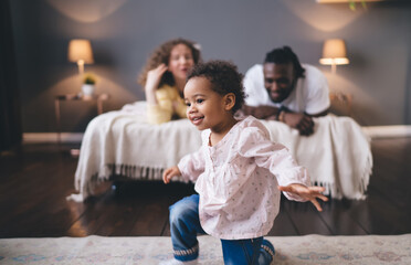 Heartwarming of diverse family focusing on connection with pretty kid. selective focus on young child centered with blurred parents sharing moment of pure joy and togetherness in home interior