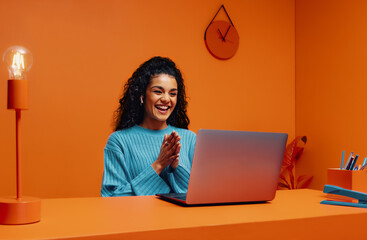 Tech recruiter woman clapping while using laptop in bright, wireless workspace