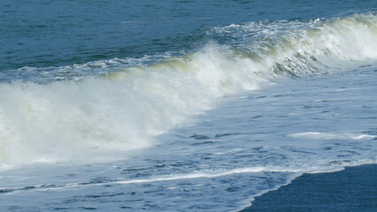 Stone Beach Of Small Pebbles Washed By Small Foamy Waves. Clear Water By The Sea. Still.