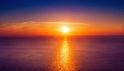 Obraz premium Golden Hour Horizon: A breathtaking aerial view of the sun setting over a vast expanse of water, casting a radiant glow and creating a mesmerizing gradient of colors in the sky.