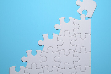 Piezas de puzzle blancas formando una escalera, concepto de superaci&oacute;n. 