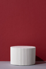 White round podium on a gray table on a red wall. Geometric premium scene for advertising and presentation your product. Showcase, display case
