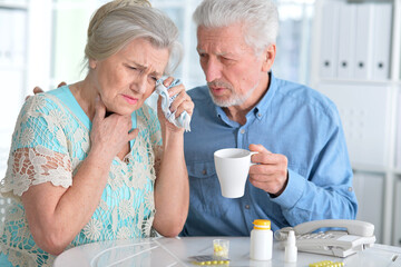 An elderly couple is sick and takes medication at home