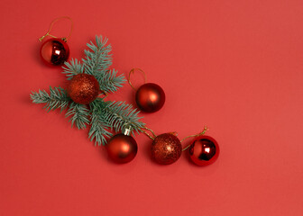 Red glitter Christmas ornaments with pine branch on red background