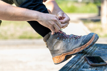 Close-up of man tying laces on worn hiking boots