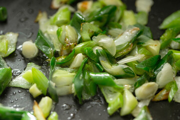 Stir-fried green onions in a pan