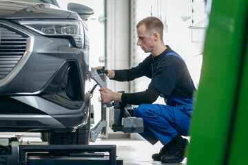 Auto mechanic adjustment automobile wheel alignment work at repair service station