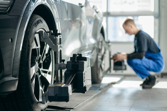Auto mechanic adjustment automobile wheel alignment work at repair service station