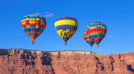 Obraz premium Colorful Hot Air Balloons Flying Over Majestic Red Rock Cliffs Landscape