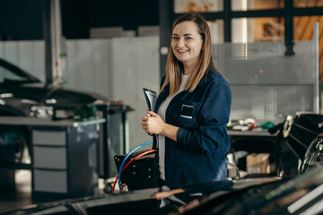 Female inspector checks the work of a mechanic in a car repair shop
