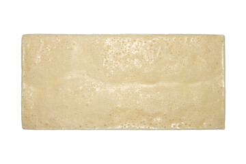 A bar of white porous chocolate on a white background.White milk porous chocolate.