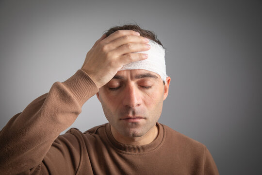 Caucasian man with a bandage on head.