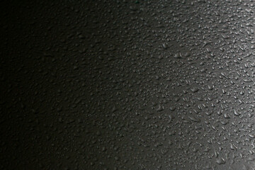 Close-up of water drops. Raindrops, on the surface of a car. Gradient from dark to light.  Set it up as a cool background.  Dimensional, wallpaper.