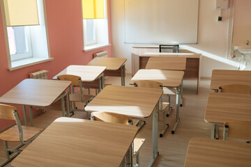 A classroom with wooden desks and chairs
