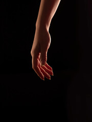 relaxed woman's hand, black background, backlit