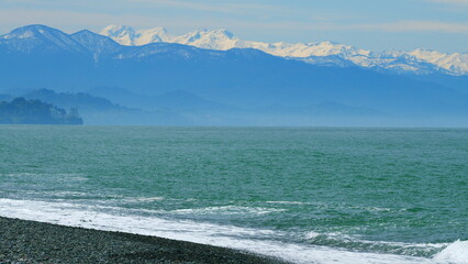 Foam Waves On The Beach. Daylight With Blue Clear Sky. Waves On The Sea On A Pebble Beach. Slow motion.