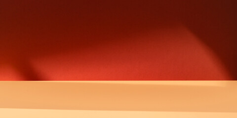 Obraz premium Minimalist, dark red abstract background with natural light shadows. Mock up for presentation, branding products, cosmetics food or jewelry.