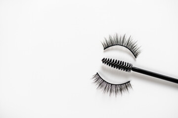 Short eyelash and eyebrow makeup brush with false eyelashes on white background. Women beauty and eye makeup.