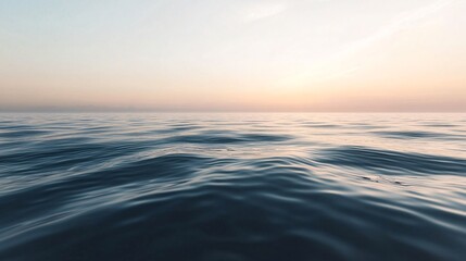 Obraz premium Calm ocean reflecting pastel sunset colors during twilight