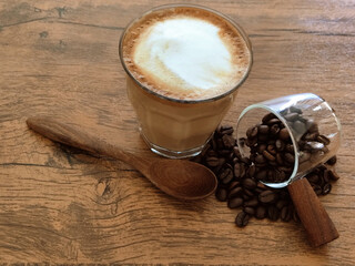 Hot latte with coffee beans on a wooden table