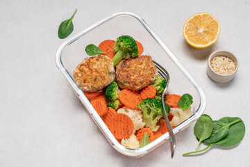 Broccoli, carrot, cauliflower and chicken breast cutlets. Healthy food in glass container on white background