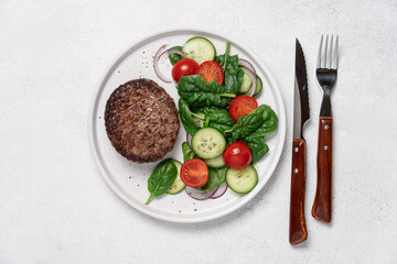 Grilled marbled beef with spinach salad on a plate on a white background with copy space. Protein lunch, healthy eating