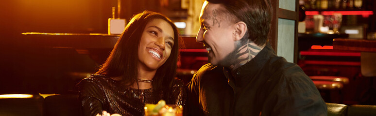 Beautiful couple shares a joyful moment on their date, surrounded by vibrant nightlife.
