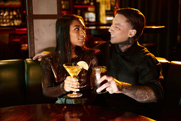 Young couple shares a moment together over drinks during a lively night out.