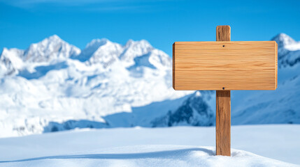 Blank wooden sign stands amidst a snowy mountain landscape, under a clear blue sky, inviting messages or directions.