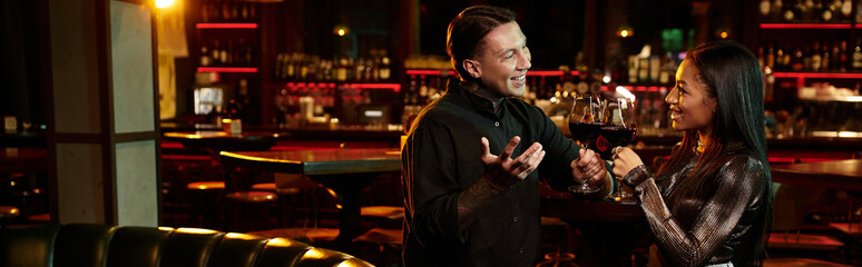 A young couple shares laughter and drinks, capturing the essence of a lively night out.