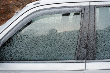 Obraz premium A close-up of a frozen car window covered with ice