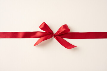 An elegant red ribbon tied in a bow on a cream background, symbolizing love and celebrations. Perfect for Valentine's Day, weddings, and holidays, creating a festive and romantic atmosphere