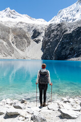 Impressed hiker standing on the shore of the Laguna 69, Andes, Peru.