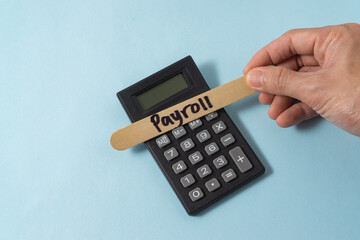 Financial concept with a hand writing payroll on ice cream stick