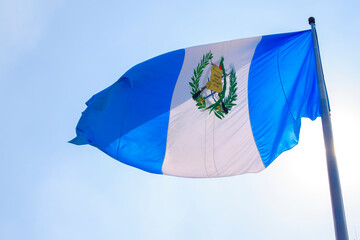 Flag of Guatemala, free in the wind with blue sky, coat of arms, Central America. September 15...