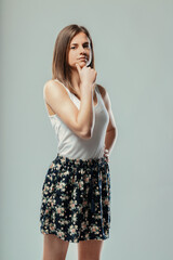 Fototapeta premium Young woman thinking and touching chin with hand