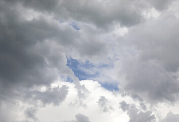 blue sky among the many gray and black clouds threatening rain