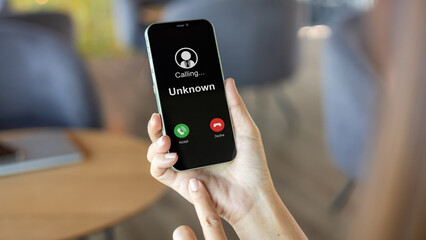 Scam with mobile phone, Woman receives a phone call from an unknown number, Concept of scammers or...