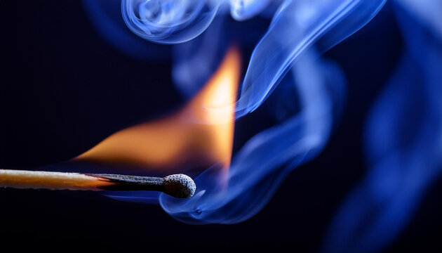 Burning match with bright flame and blue smoke on dark backdrop.
