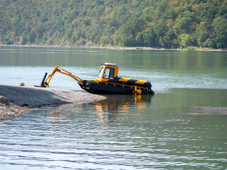 Abrau Durso, Russia 28 August 2024: Municipal aquatic weed harvesting equipment passes along lake Abrau-Durso