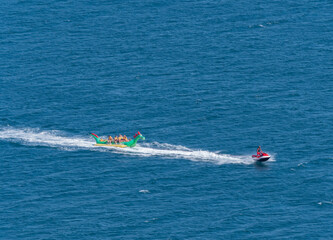Jet Ski and inflatable banana towed by a boat near de coastline of Black Sea coast in Novorossiysk
