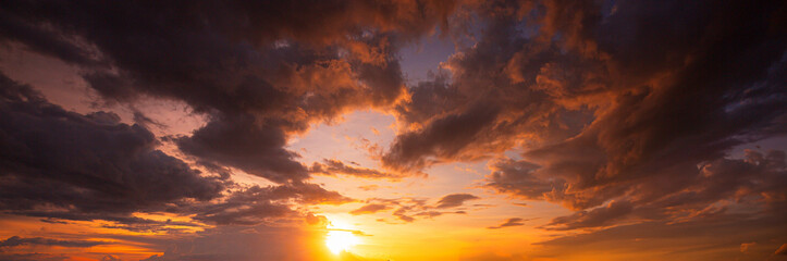 Clouds and stormy sky,The sun's rays penetrate through the dark clouds during sunset, panorama,Sunrise background. Dramatic majestic scenery sunset. Sky with clouds in Sunrise sky light background. 