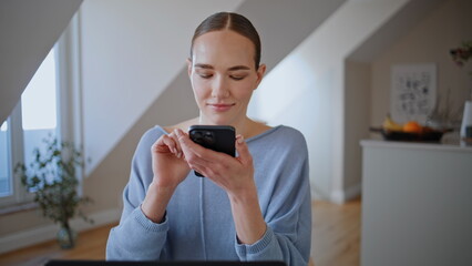 Domestic lady answering message typing mobile phone in workplace table closeup