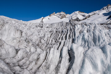 a crevassed glacier peak with colored ice