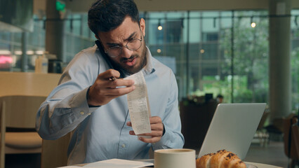 Multitasking busy serious businessman Arabian Indian male guy business man worker visitor in cafe...