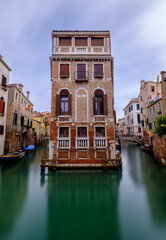 Long exposure of venetian palazzo surrounded by canals
