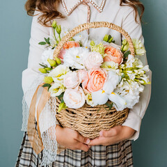 A little girl, filled with joy and exuberance, carefully holds a beautifully woven basket that is...